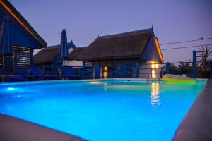 a swimming pool in front of a house at night at Déjà Blue - ADULT ONLY in Sfântu Gheorghe
