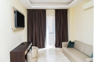 ein Wohnzimmer mit Sofa und Fernseher in der Unterkunft Hôtel Bachou in Dakar