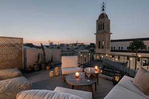 a balcony with couches and a table and a clock tower at Soleil boutique house with terrace in Rethymno Town