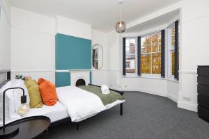 Timeless Elegance 4-Bed Victorian Charm في ليستر: غرفة نوم بسرير مع موقد ومغسلة