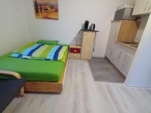 ein Schlafzimmer mit einem grünen Bett in einem Zimmer in der Unterkunft Voll ausgestattetes Apartment in Kassel