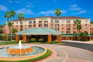 a hotel with a fountain in front of a building at Courtyard by Marriott Orlando Lake Buena Vista in the Marriott Village in Orlando