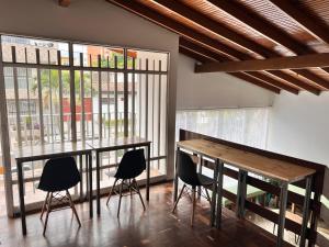 uma sala de jantar com uma mesa de madeira e cadeiras em Sereni Laureles Hotel Cafe em Medellín
