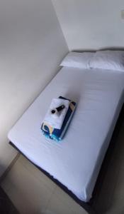 - un lit blanc avec une serviette dans l'établissement Hotel La Estrella, à San Luis