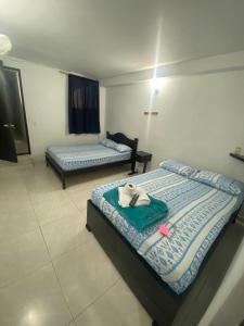 - 2 lits dans une chambre d'hôtel avec des serviettes dans l'établissement Hotel La Estrella, à San Luis