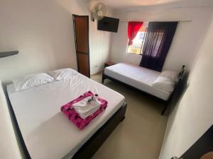 Cette chambre comprend 2 lits et un sac rose. dans l'établissement Hotel La Estrella, à San Luis