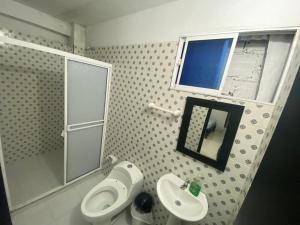 La salle de bains est pourvue de toilettes, d'un lavabo et d'un miroir. dans l'établissement Hotel La Estrella, à San Luis