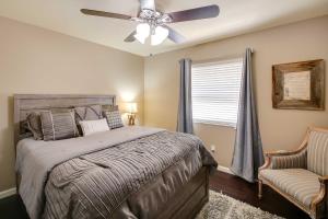 a bedroom with a bed with a ceiling fan and a chair at Lakefront Haven Near Oaklawn and Casino Resort! in Hot Springs