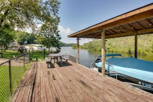 a wooden dock with a boat on a river at Lakefront Haven Near Oaklawn and Casino Resort! in Hot Springs