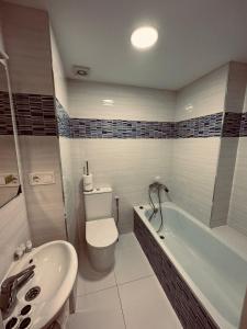 a bathroom with a toilet and a tub and a sink at Apartamento de Lucerito in Jaca