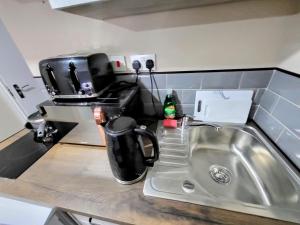 a kitchen counter with a sink and a coffee pot at Stay Sleep Rest - NG2 in Nottingham