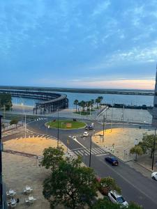 Blick auf eine Stadt mit einem Pier und das Meer in der Unterkunft Ría de Huelva in Huelva