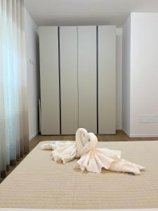 una habitación blanca con un cisne sobre una cama en Le due sorelle ALE, en Civitanova Marche