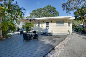a wooden deck with a table and an umbrella at Ozona Studio with Shared Deck - Steps to Gulf! in Palm Harbor