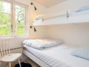 エーベルトフトにあるTwo-Bedroom Holiday home in Ebeltoft 15のベッドルーム1室(二段ベッド2台、椅子付)