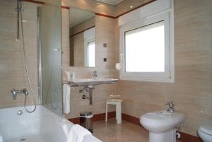 a bathroom with a sink and a tub and a toilet at Hostal Moreno in Silla