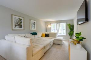 a living room with a white couch and a flat screen tv at Lovely Riverdale Retreat with Private Pool and Yard! in Riverdale