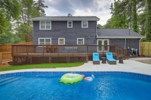 a swimming pool with two chairs and a house at Lovely Riverdale Retreat with Private Pool and Yard! in Riverdale