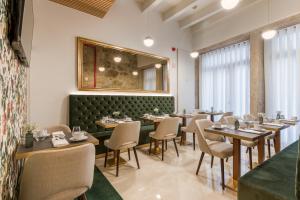 Ribeira Douro Hotel في بورتو: غرفة طعام مع طاولات وكراسي ومرآة