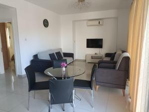 a living room with a couch and a table and chairs at Magic Beach Apartments in Kyrenia