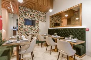 a dining room with tables and chairs and a tv at Ribeira Douro Hotel in Porto