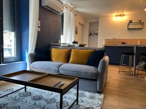 a living room with a couch and a table at Superbe Appartement Centre B in Bourges