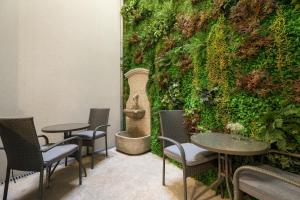 Cette chambre est dotée de tables, de chaises et d'un mur vert. dans l'établissement Ribeira Douro Hotel, à Porto