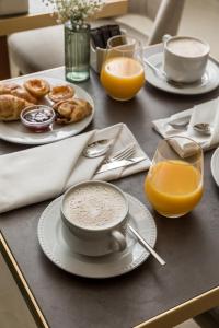 a table topped with plates of food and orange juice at Ribeira Douro Hotel in Porto +52 photos