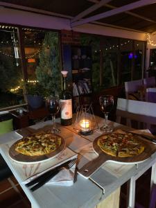 two pizzas sitting on a table with glasses of wine at El Refugio del Santo in El Lindero
