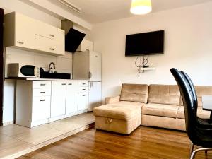 a living room with a couch and a table and a tv at Familly Apartament 3 in Międzyzdroje