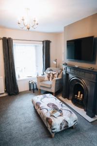 a living room with a fireplace and a couch and a tv at Menstrie Castle Stay in Stirling