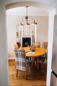 uma sala de jantar com uma mesa de madeira e cadeiras em Menstrie Castle Stay em Stirling