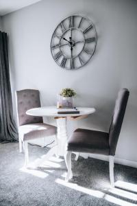 a table and two chairs and a clock on a wall at Menstrie Castle Stay in Stirling