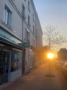 a street with the sun shining on a building at Appart Lumineux 150 m de la Gare in Bourg-en-Bresse