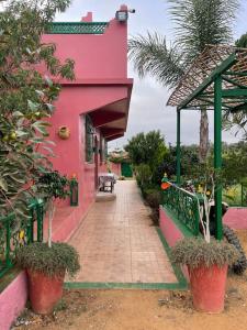 a pink house with a walkway in front of it at Lovely holiday Private villa with nature view +pool in Larache