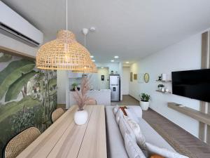 una sala da pranzo con tavolo e grande lampadario a braccio di Isthmus Concept Apartment a Città di Panama