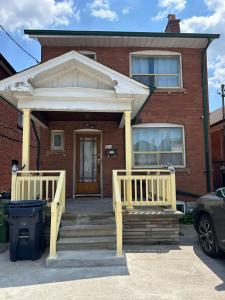a house with two wooden doors and a porch at TORONTO Midtown Spot 1 in Toronto