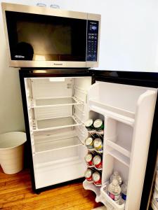 an open refrigerator with a microwave above it at TORONTO Midtown Spot 1 in Toronto