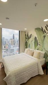 una camera da letto con un grande letto con una grande finestra di Isthmus Concept Apartment a Città di Panama