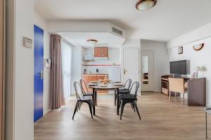 a dining room and kitchen with a table and chairs at Appart'City Confort Pau Centre in Pau