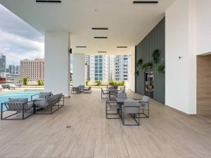 un patio con sillas y una piscina en un edificio en Isthmus Concept Apartment en Panamá