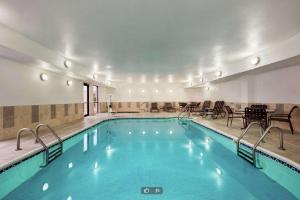 una piscina en un hotel con mesas y sillas en Hampton Inn Abilene, en Abilene