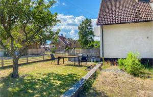 a backyard with a table and chairs and a tree at 1 Bedroom Amazing Apartment In Frbo in Fårbo