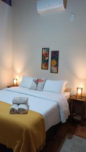 a bedroom with a large white bed with two towels on it at Pousada Estrelícia in Cunha