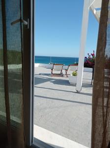 - une vue sur la plage depuis une porte coulissante en verre dans l'établissement Maistrali, à Provatas