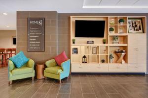 zona de estar con 2 sillas y TV en Home2Suites by Hilton Augusta, en Augusta