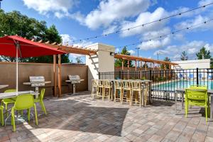 un patio con tavoli, sedie e piscina di Home2Suites by Hilton Augusta ad Augusta