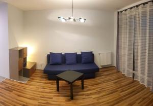 a living room with a blue couch and a table at Mini Apartament Kraków PN / Cracow NORTH z parkingiem in Kraków