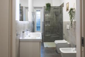 bagno bianco con lavandino e servizi igienici di Cozy flat with terrace at Trastevere train station a Roma