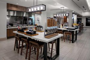 a kitchen with a counter with chairs and tables at Hilton Garden Inn Atlanta Perimeter Center in Atlanta